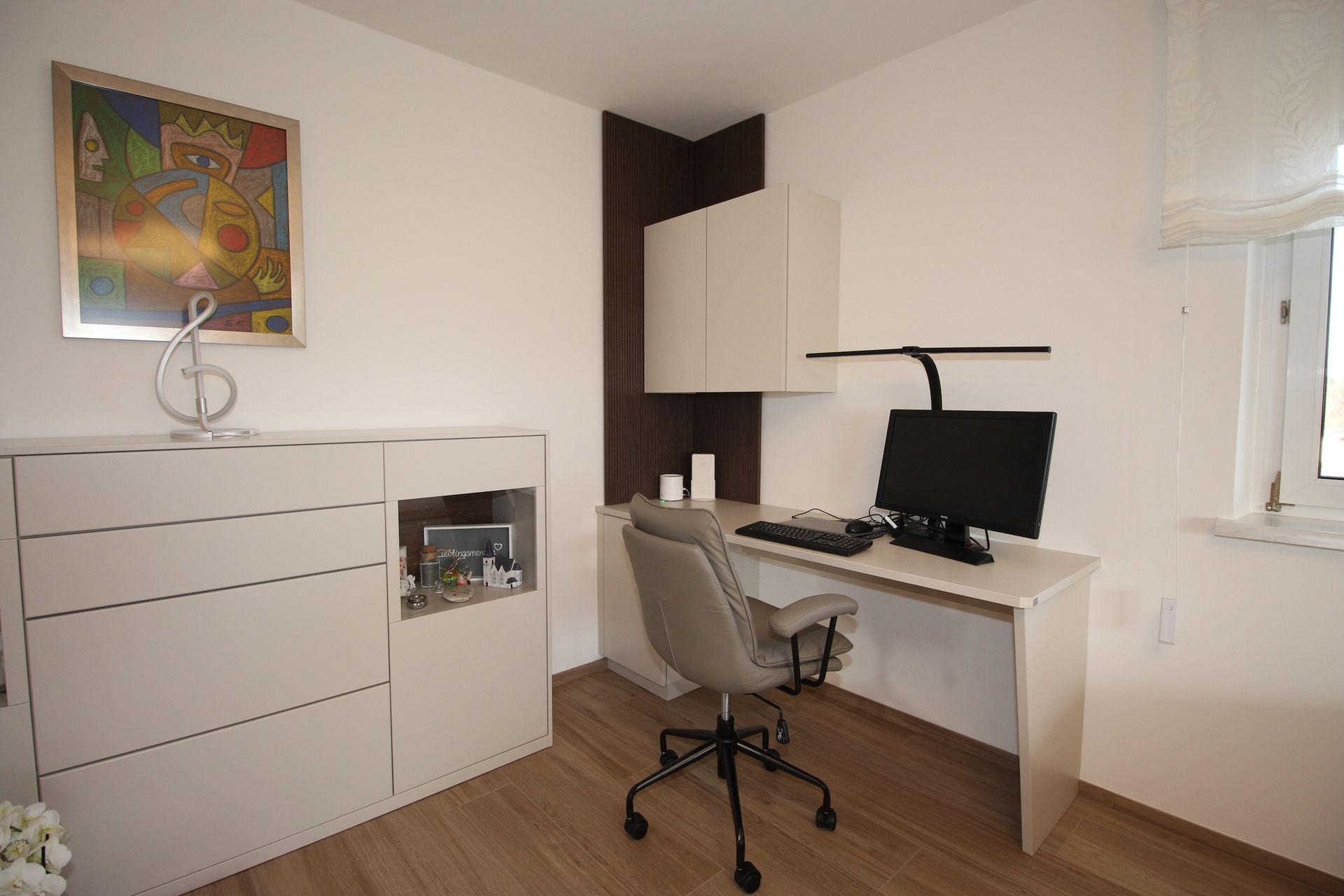 Moderner weißer Schreibtisch mit zwei Monitoren in hellem Büro.