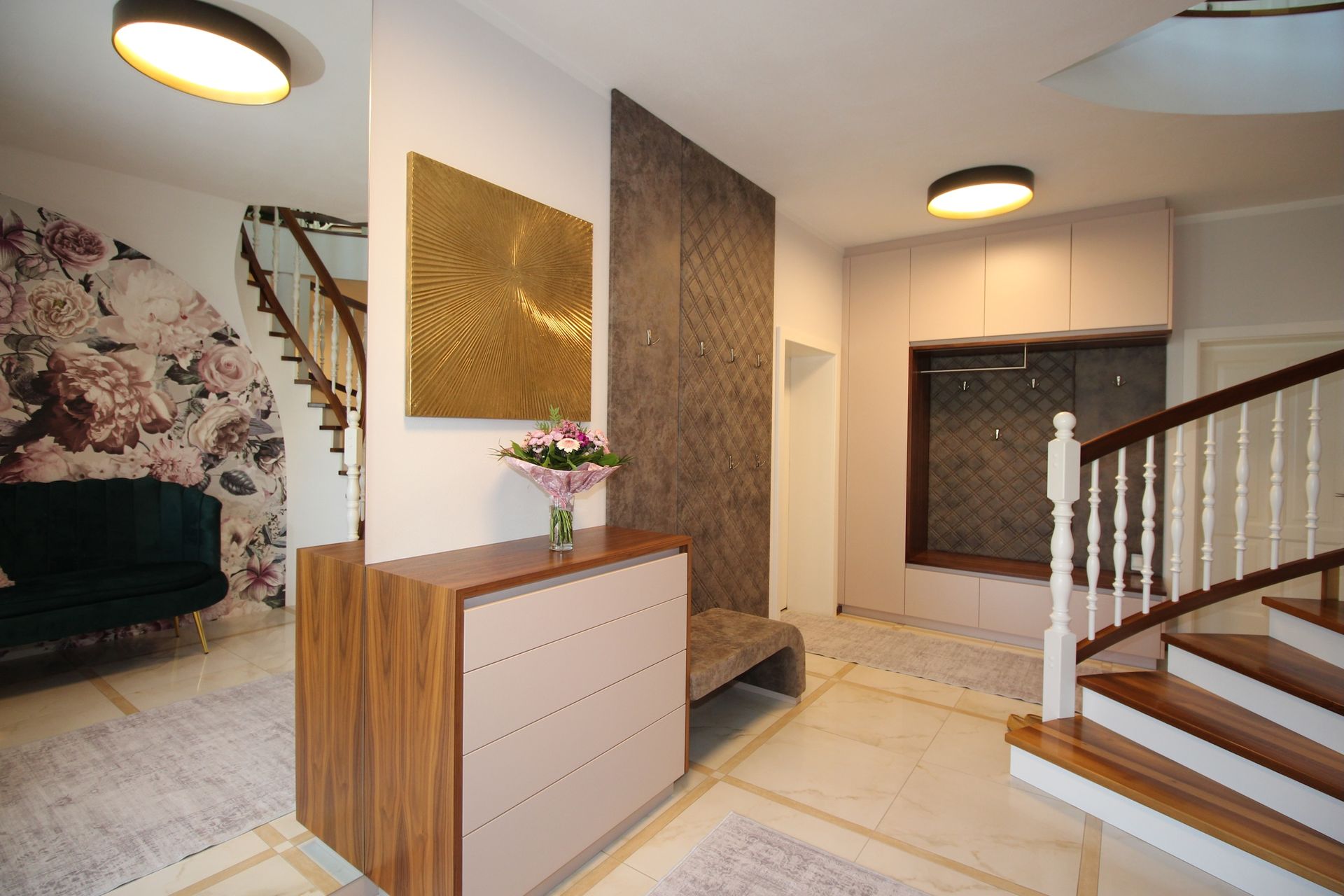 Heller Eingangsbereich mit Garderobe, Spiegel und Naturstein-Akzentwand.