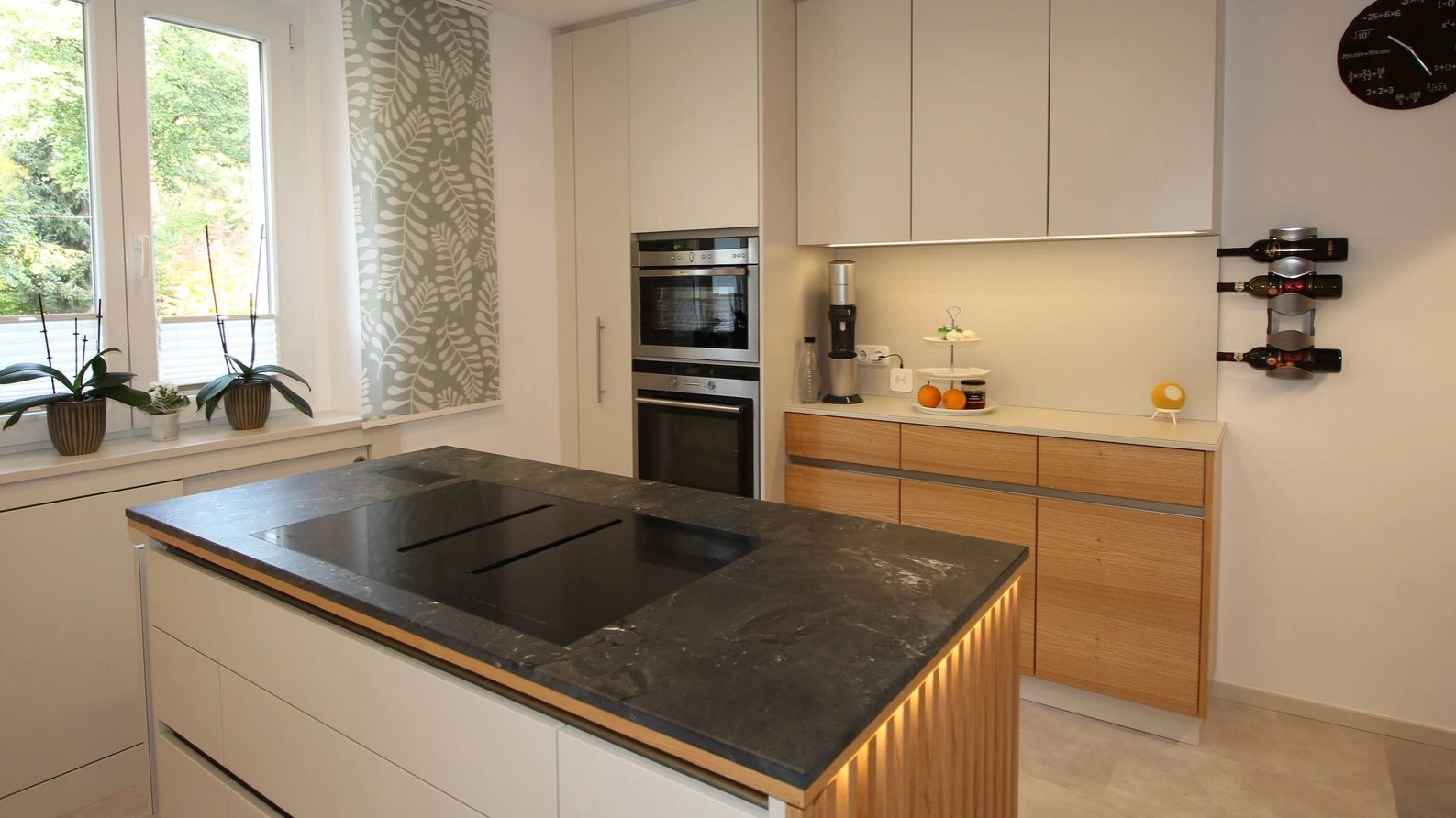 Moderne dunkle Kücheninsel mit indirekter Beleuchtung.