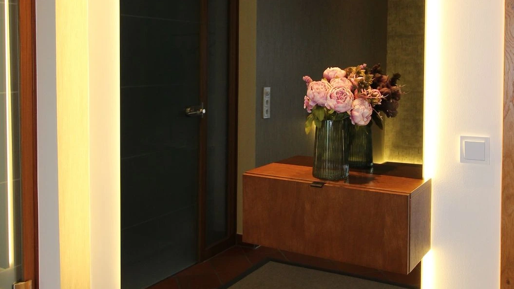 Dunkle Tür und Sideboard im Eingangsbereich.