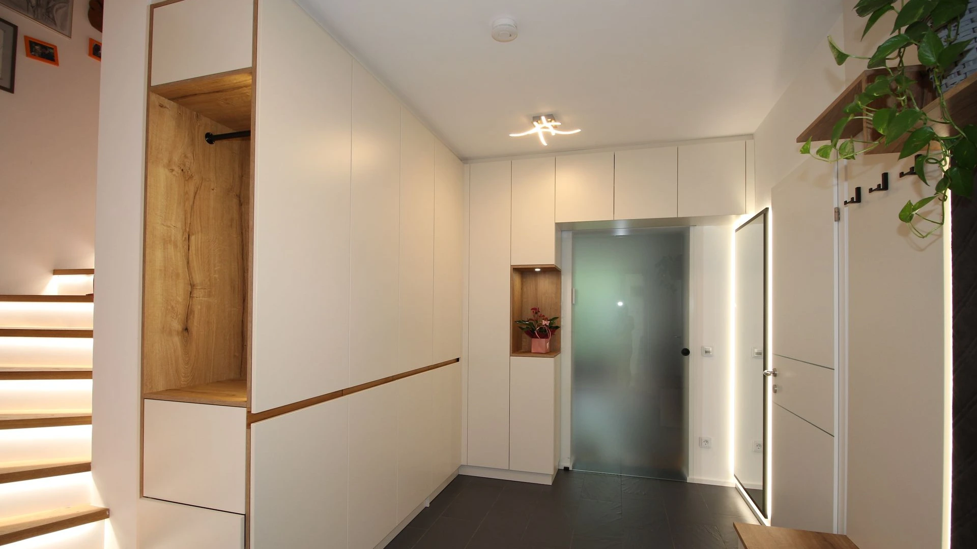 Helles Vorhaus mit moderner weißer Garderobe.