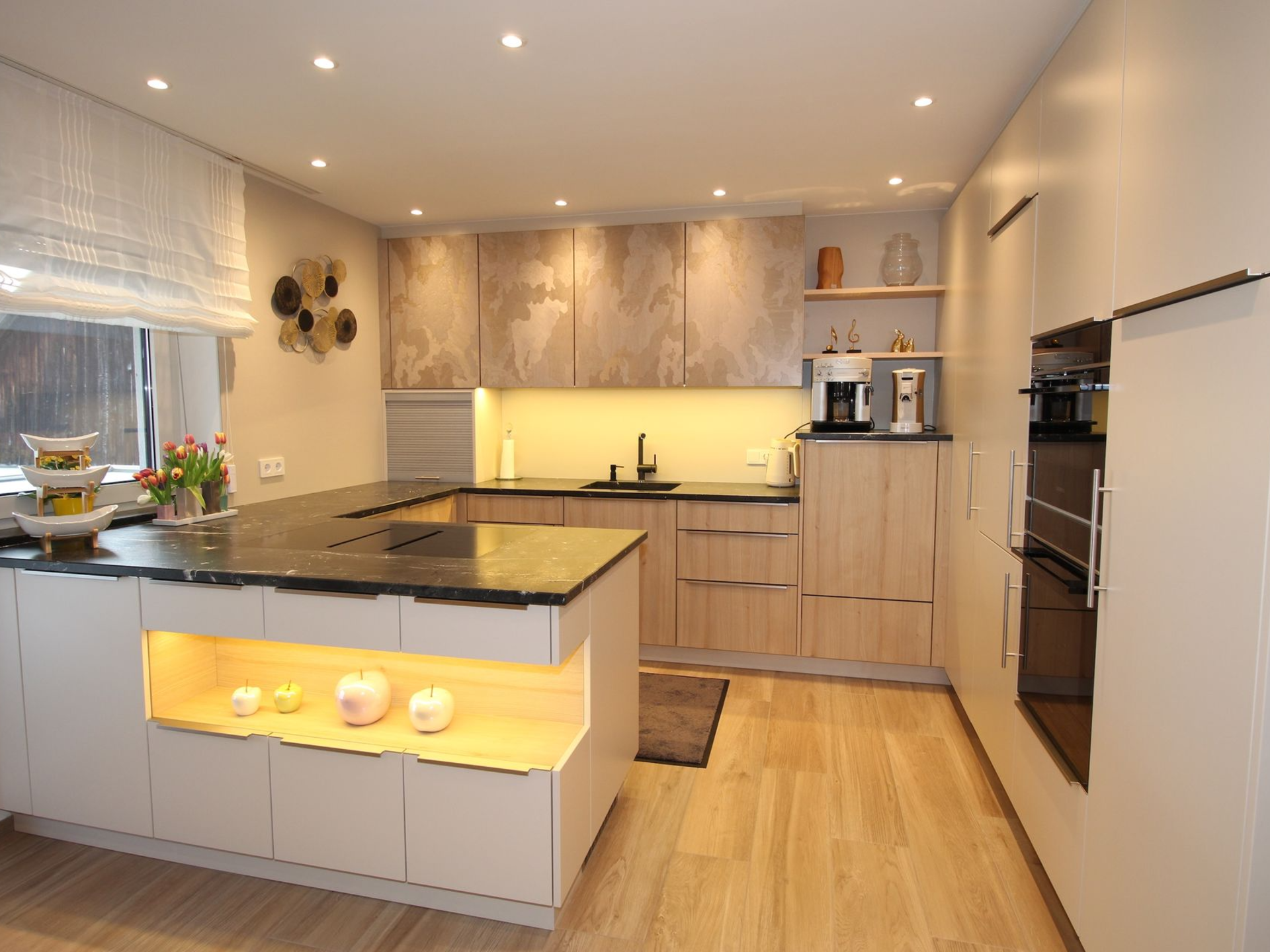 Helle Tischler-Küche mit integrierter Frühstücksbar.