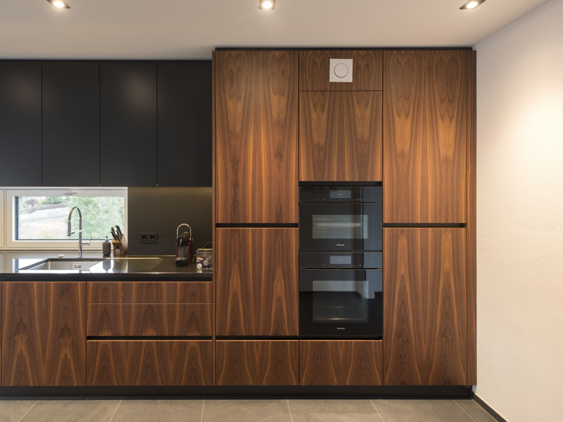 Wandbündige Küchenschränke in dunkler Holzoptik.