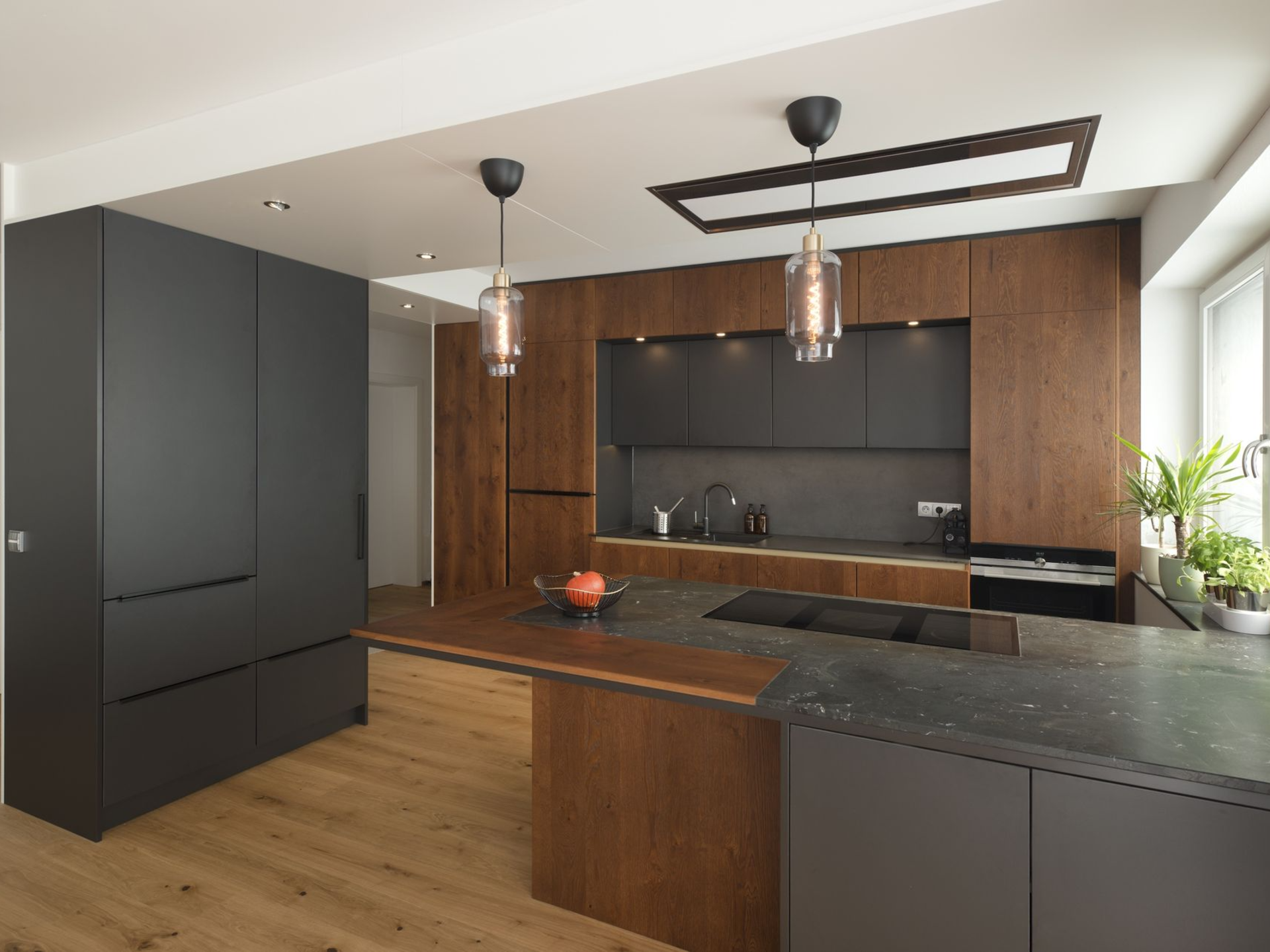 Schwarze Design-Küche mit markanten Pendelleuchten.