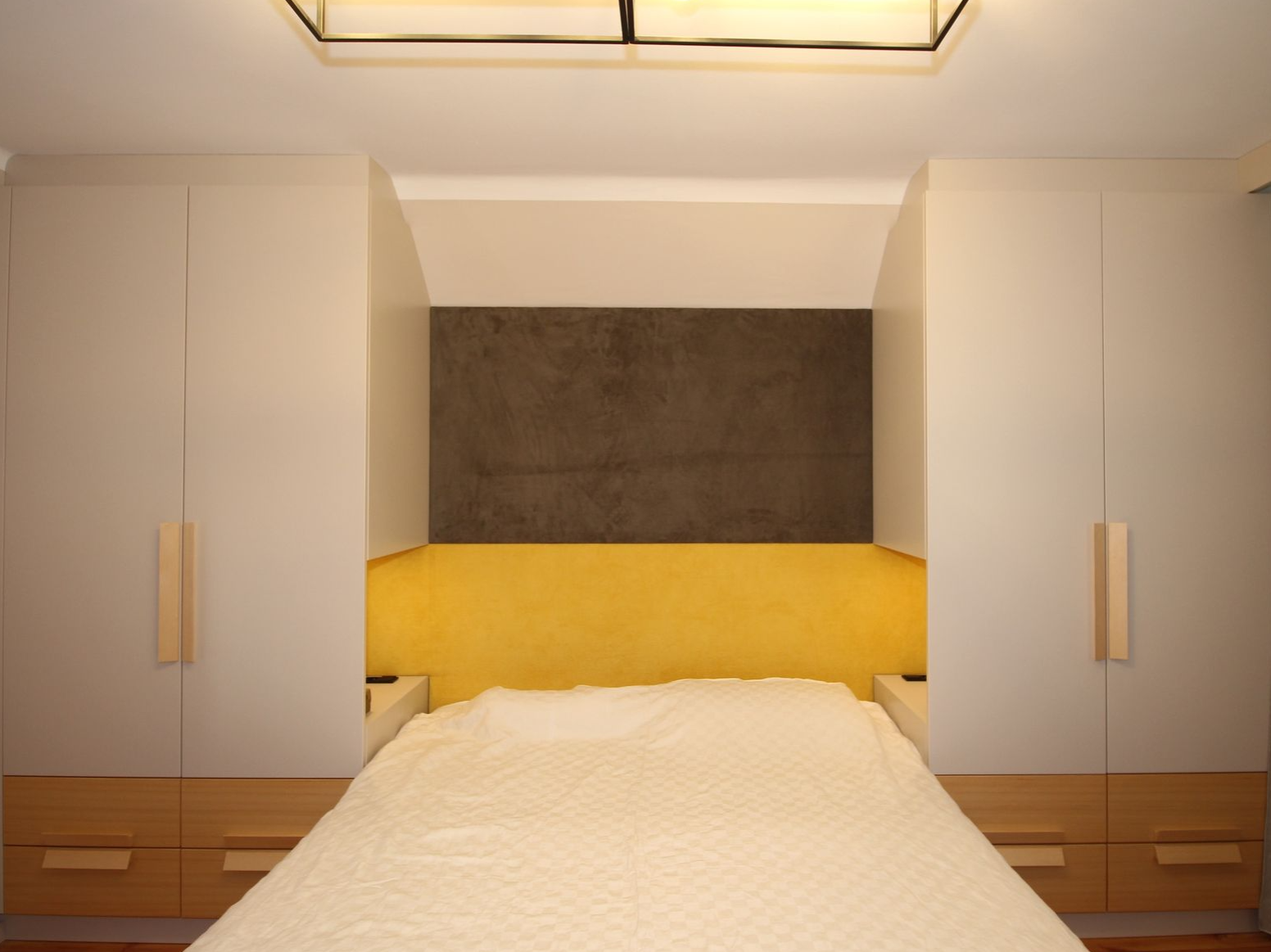 Gemütliches Polsterbett mit indirekter Wandbeleuchtung.