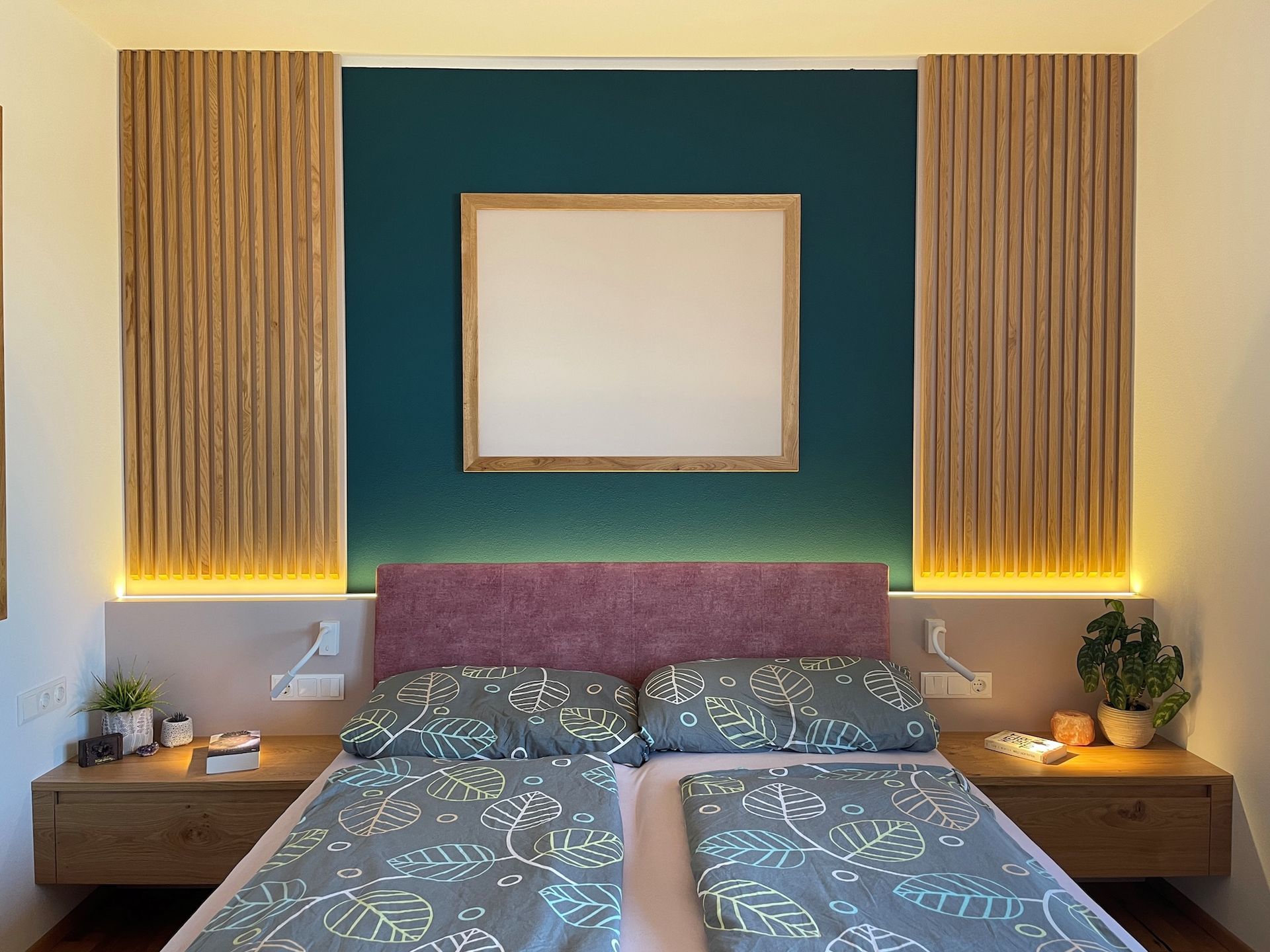 Doppelbett mit stilvoller dunkelblauer Wandgestaltung.