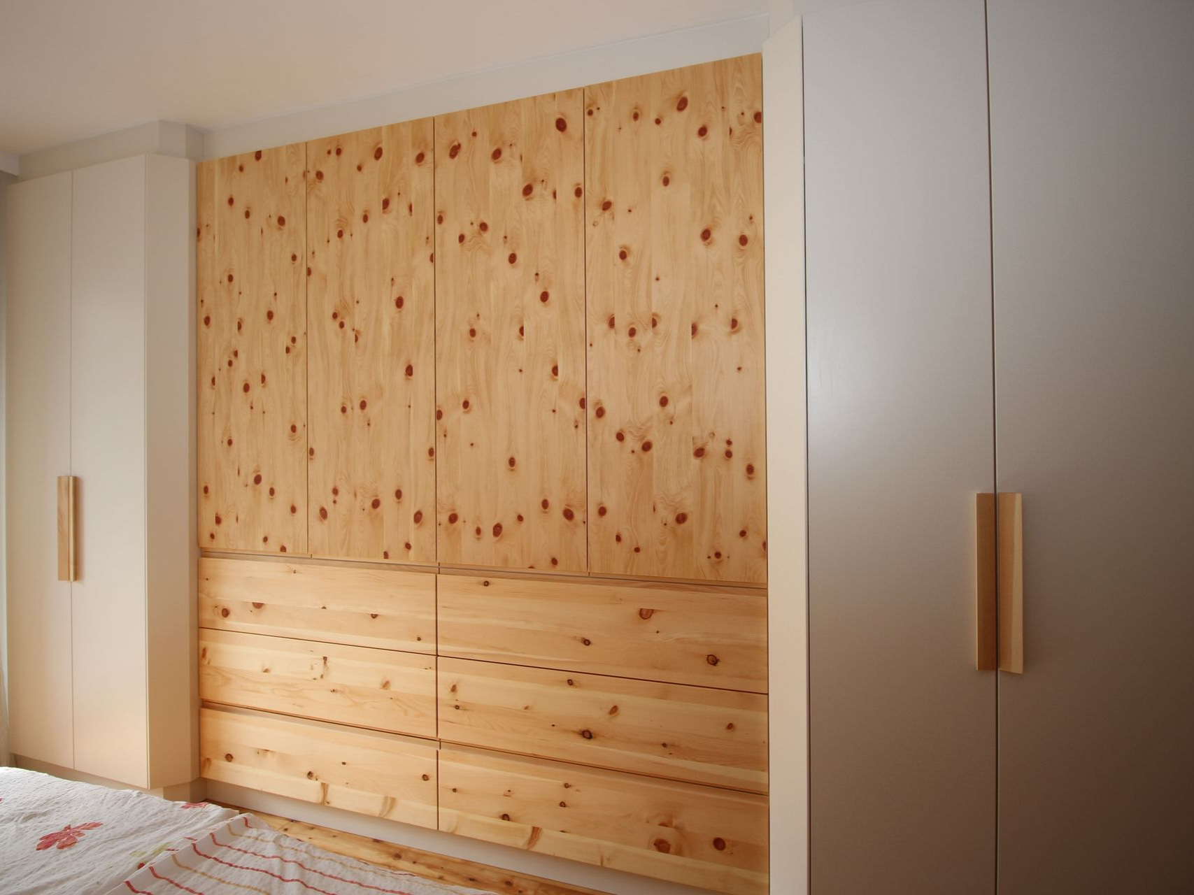 Rustikale Holzwandgestaltung hinter modernem Bett.