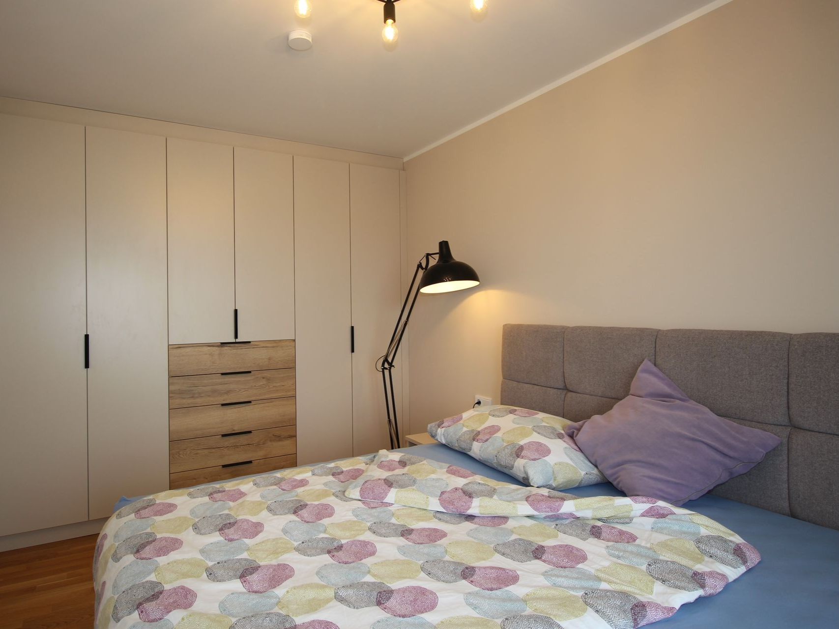 Stilvolles Doppelbett mit moderner Nachttischlampe.