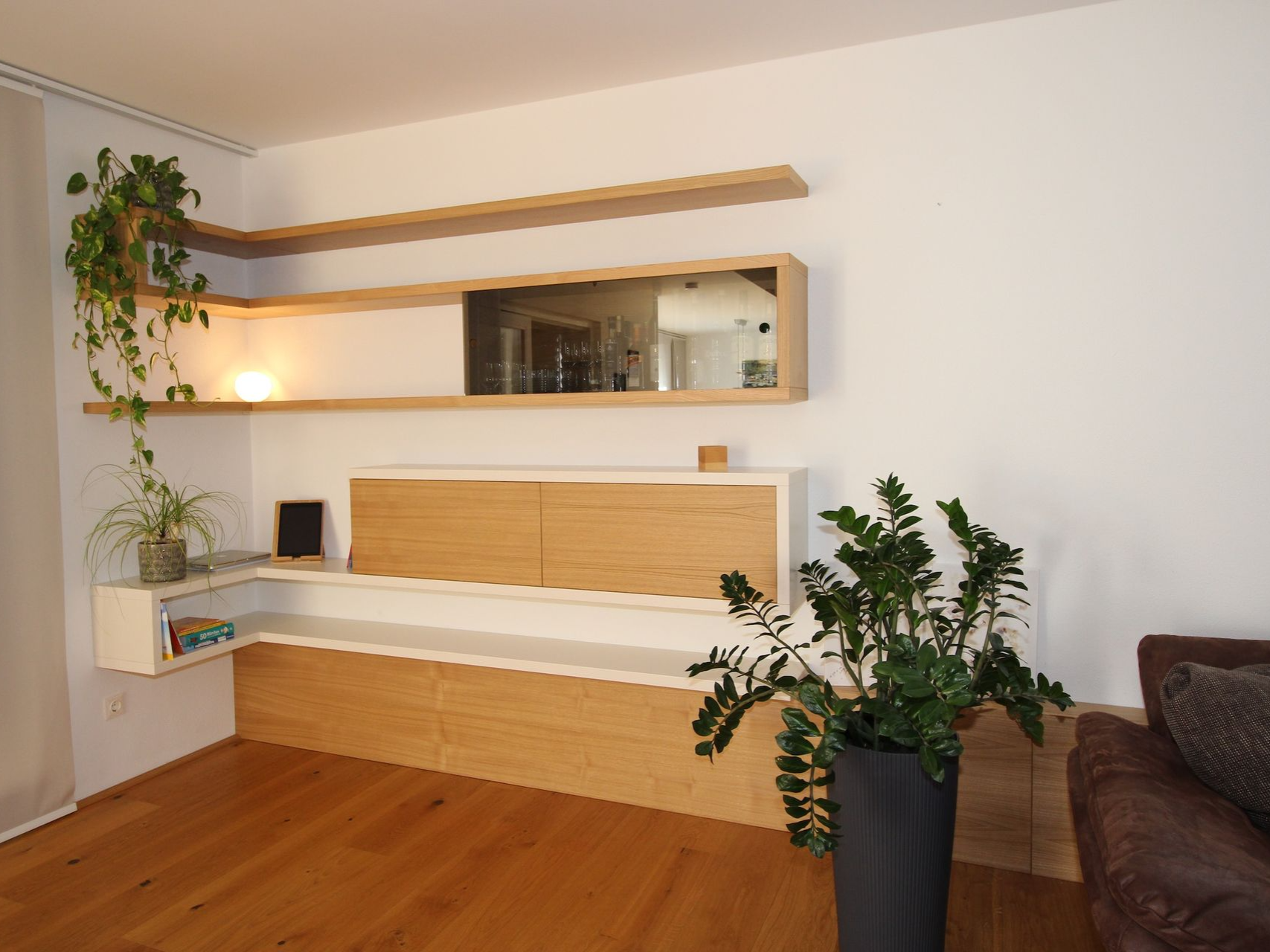 Schwebendes Sideboard unter modernem Fernseher.