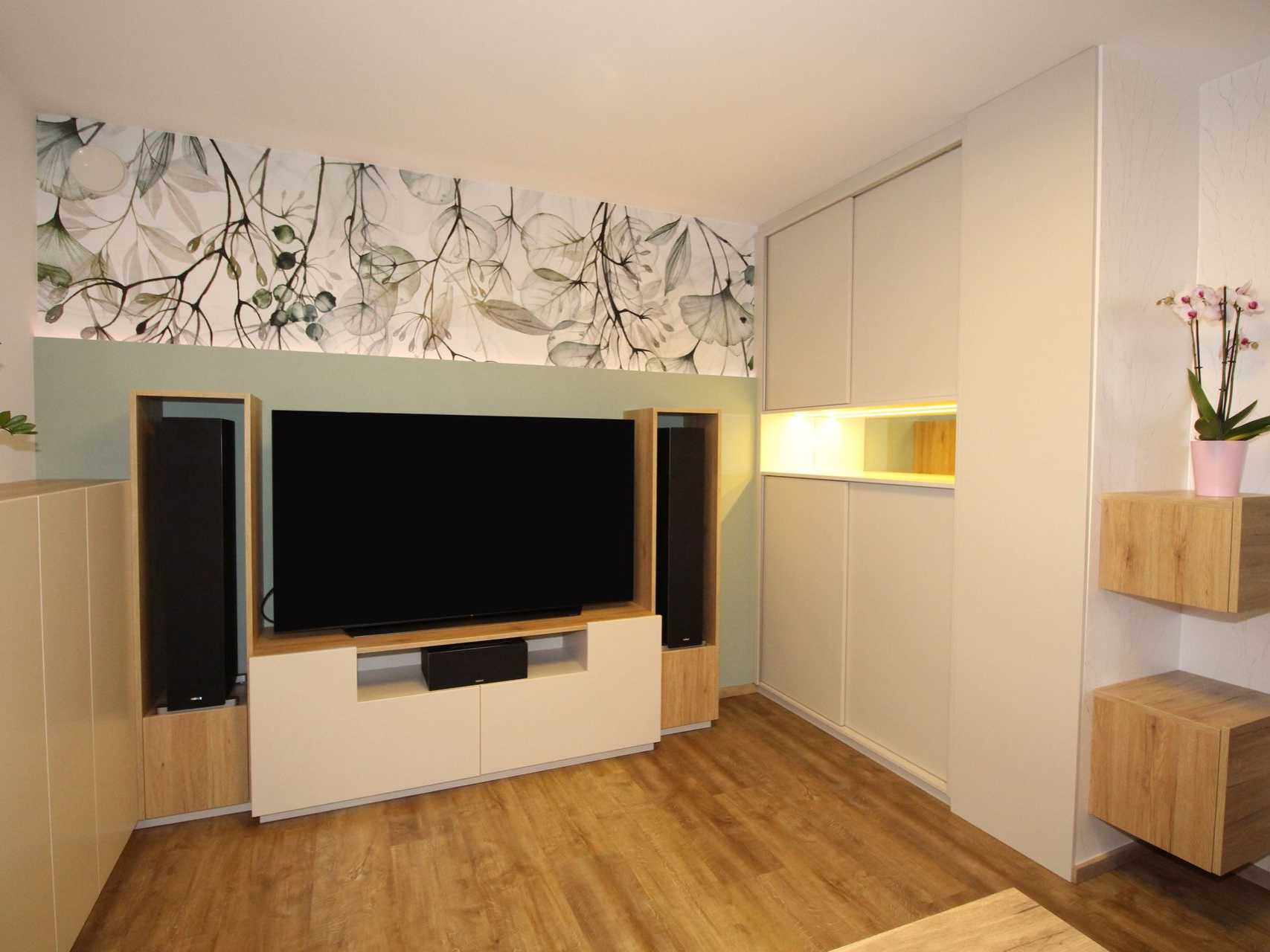 Kompakte TV-Konsole vor gemusterter Tapete.