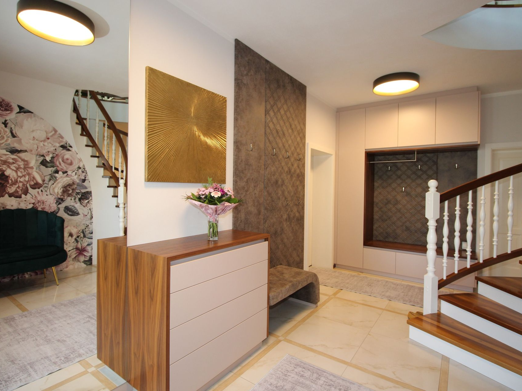 Heller Flur mit Treppenaufgang und Garderobe.