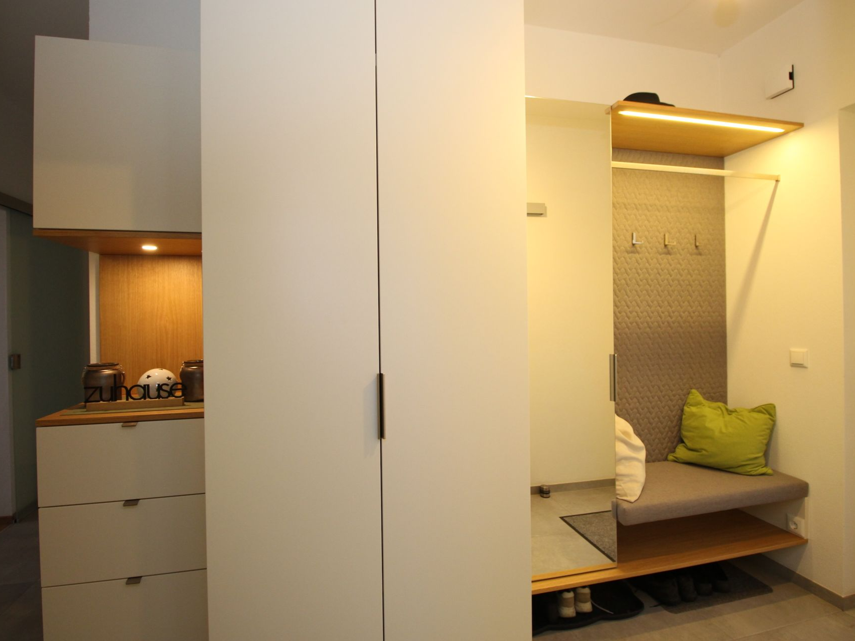 Schmaler Flur mit grifflosen weißen Schränken.