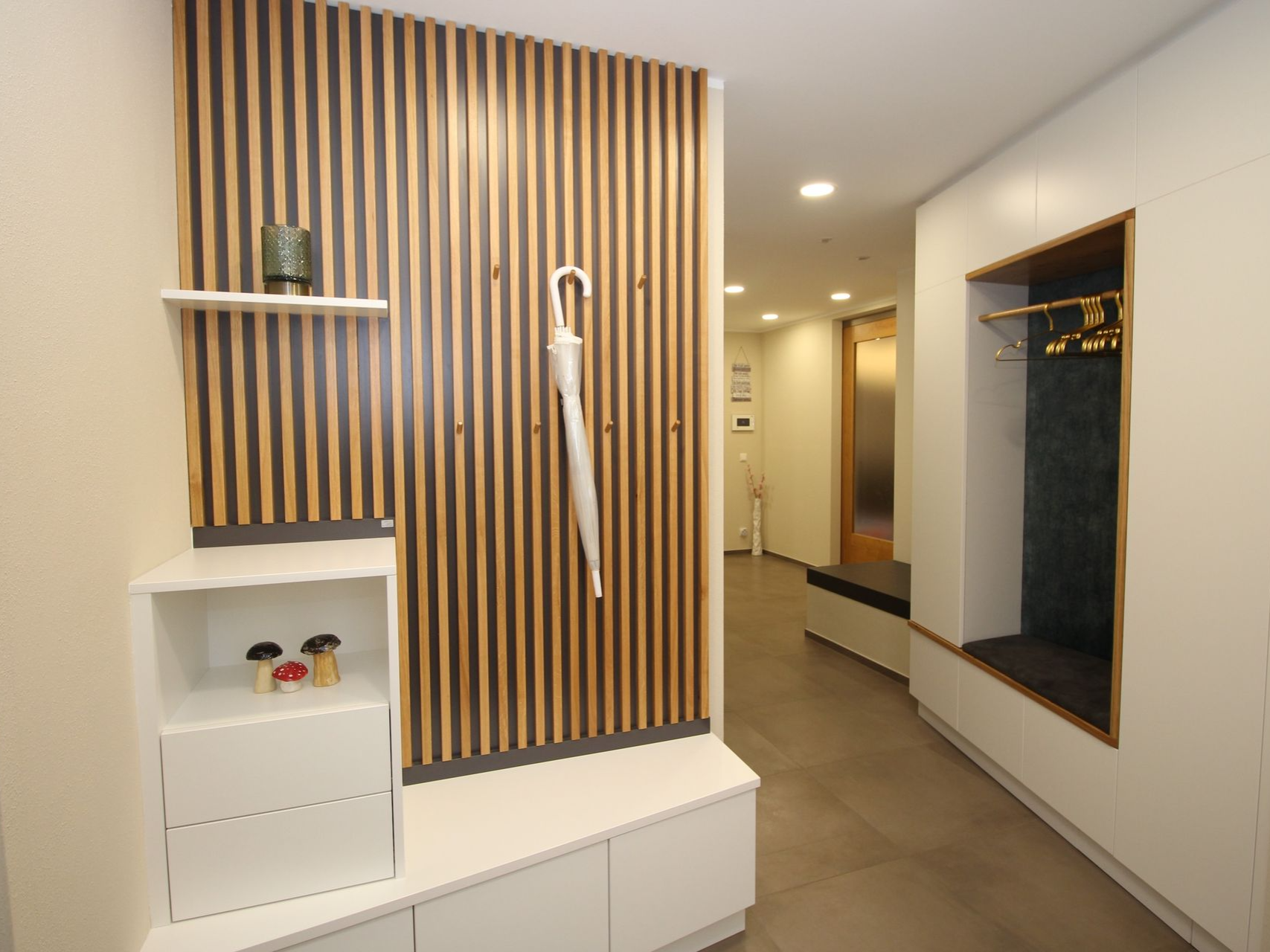 Moderne Wandverkleidung mit integrierter Garderoben-Sitznische.