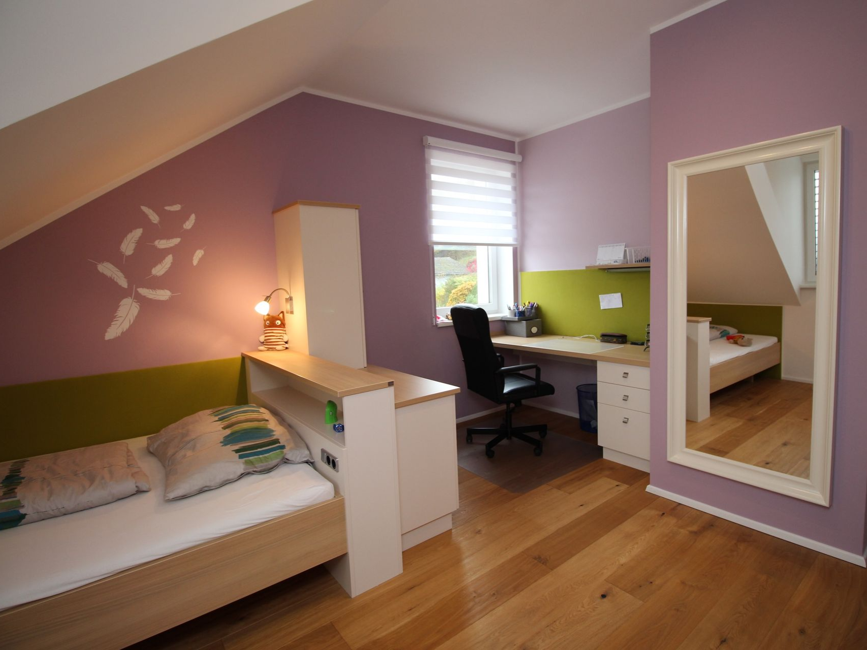 Schreibtischplatz im Kinderzimmer mit lila Akzenten.