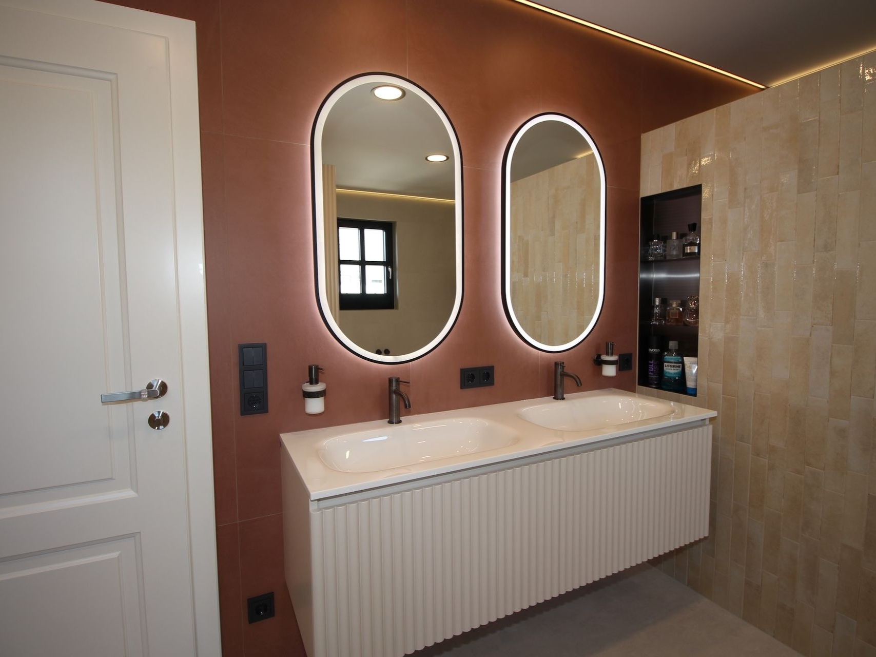 Doppelwaschtisch mit runden Spiegeln und Beleuchtung.