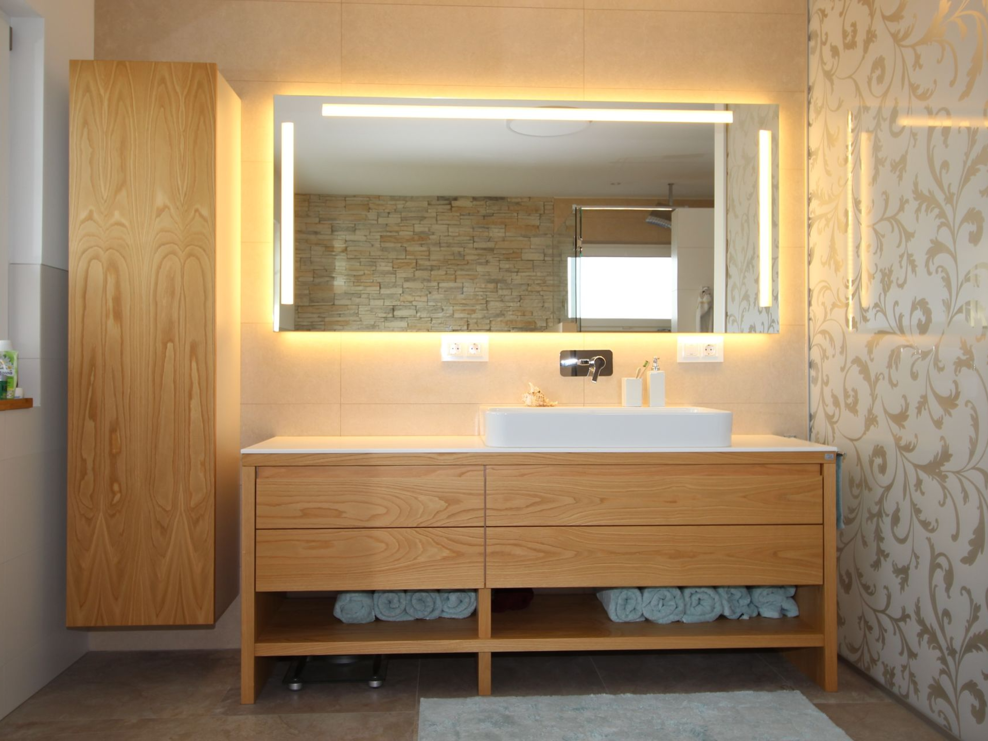 Beleuchteter Waschtisch aus Holz im Badezimmer.