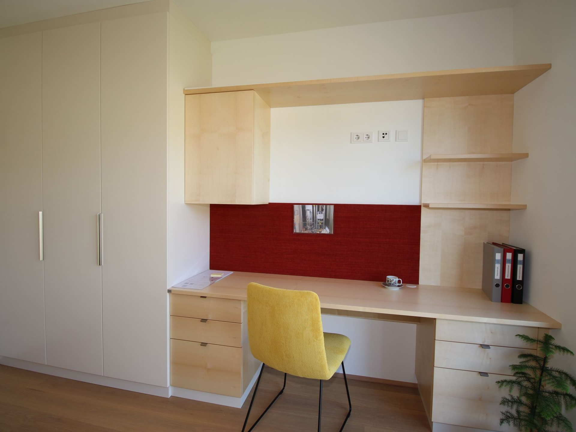 Integrierter Wandschreibtisch mit farbigen Akzenten.