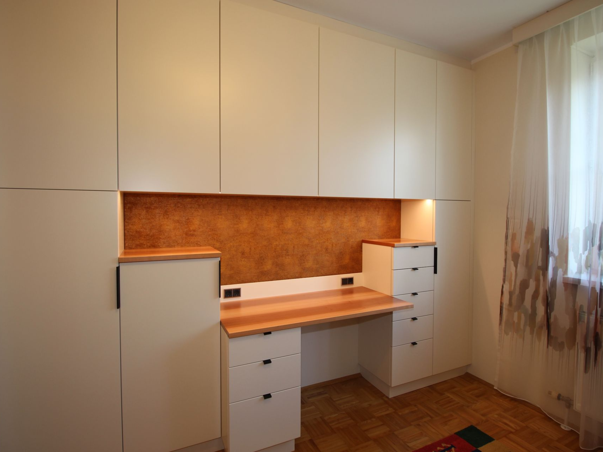 Maßgefertigter Arbeitsplatz mit hellen Holzfronten.